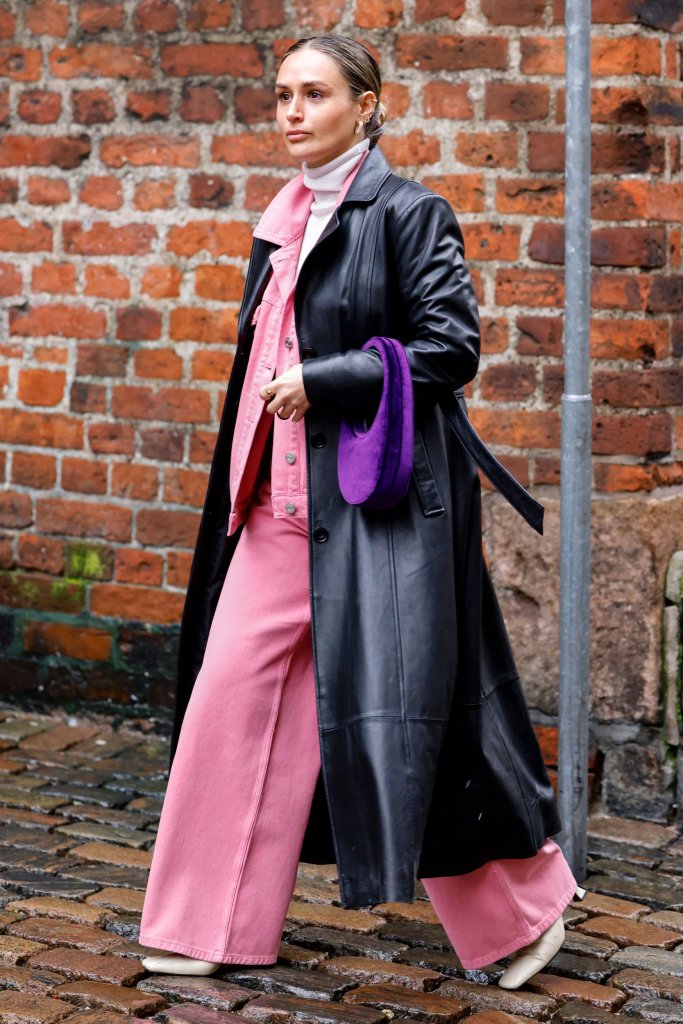 Girl in pink wide leg jeans, matching denim jacket and leather coat.